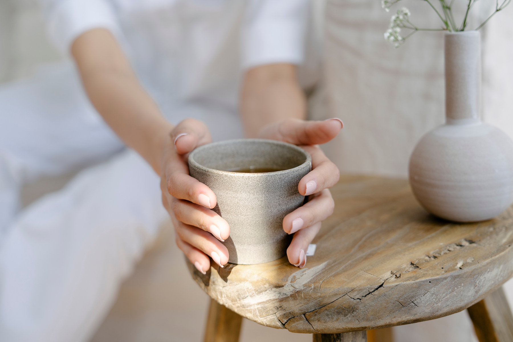 Woman warming hands with ceramic cup